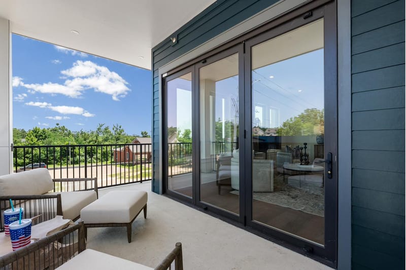 Covered balcony with lounge seating and sliding glass doors to the living room