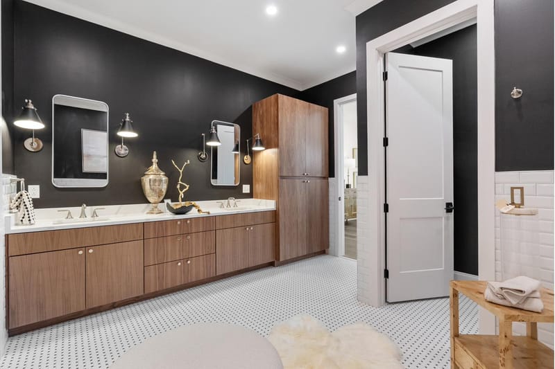Primary bath double vanity with a walnut linen tower and penny-tile floor