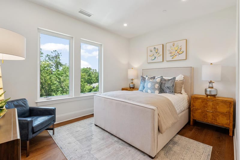 Bedroom with an upholstered bed, a window, and a leather reading chair