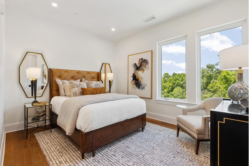 Bedroom with a tufted leather headboard and treetop views