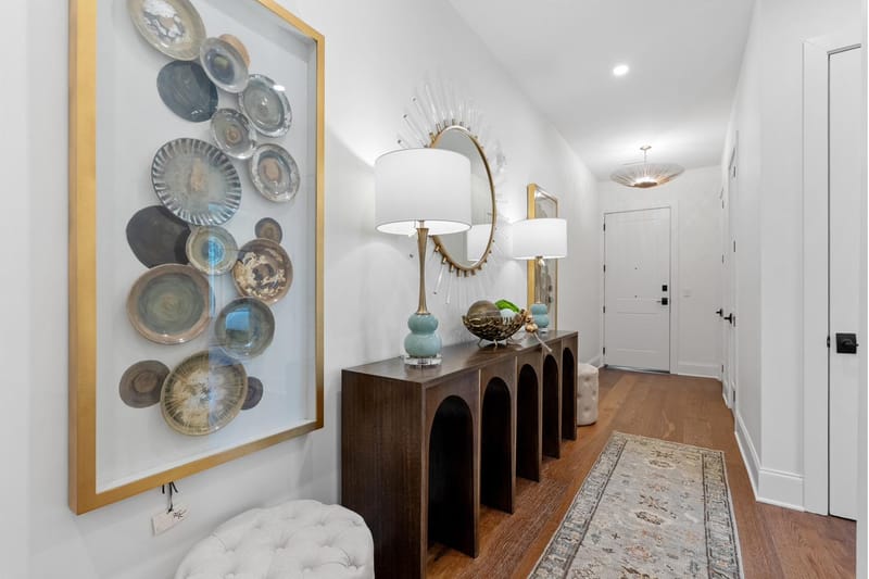 Entry hall with a console table, framed art, and oak floors