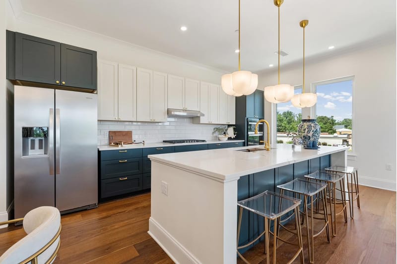Kitchen with stainless refrigerator, marble island, and counter seating